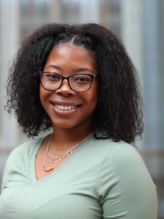 portrait of N'Dea Jackson with glass windows in the background.