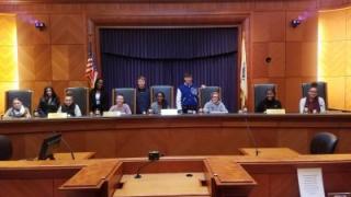 photo of students sitting at a judge's desk at John Adams Courthouse