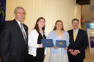 photo of two award recipients standing with Athletic Director Catabia and Senator Walter Timilty