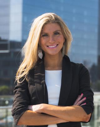 photo of Lindsay Higgins, class of 2007 graduated from the Cosmetology program smiling at the camera while on Boston Harborwalk 