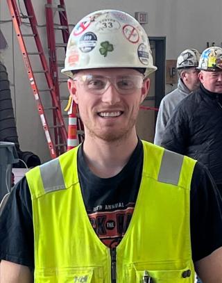 photo of Sean Arnstein, class of 2015 graduate from the Construction Technology program smiling at the camera while at a construction job site.