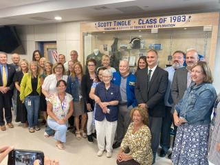 Teachers and administrators gathered in the lobby of Blue Hills Regional Technical School with NASA astronaut Scott Tingle, along with his family, celebrating the unveiling of a display case containing artifacts from his career on Monday, Aug. 25.